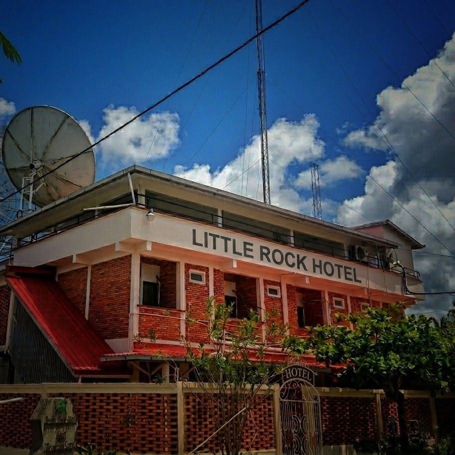 The Little Rock Hotel — red brick and white trim, with the broadcast tower and satellite dish rising behind it